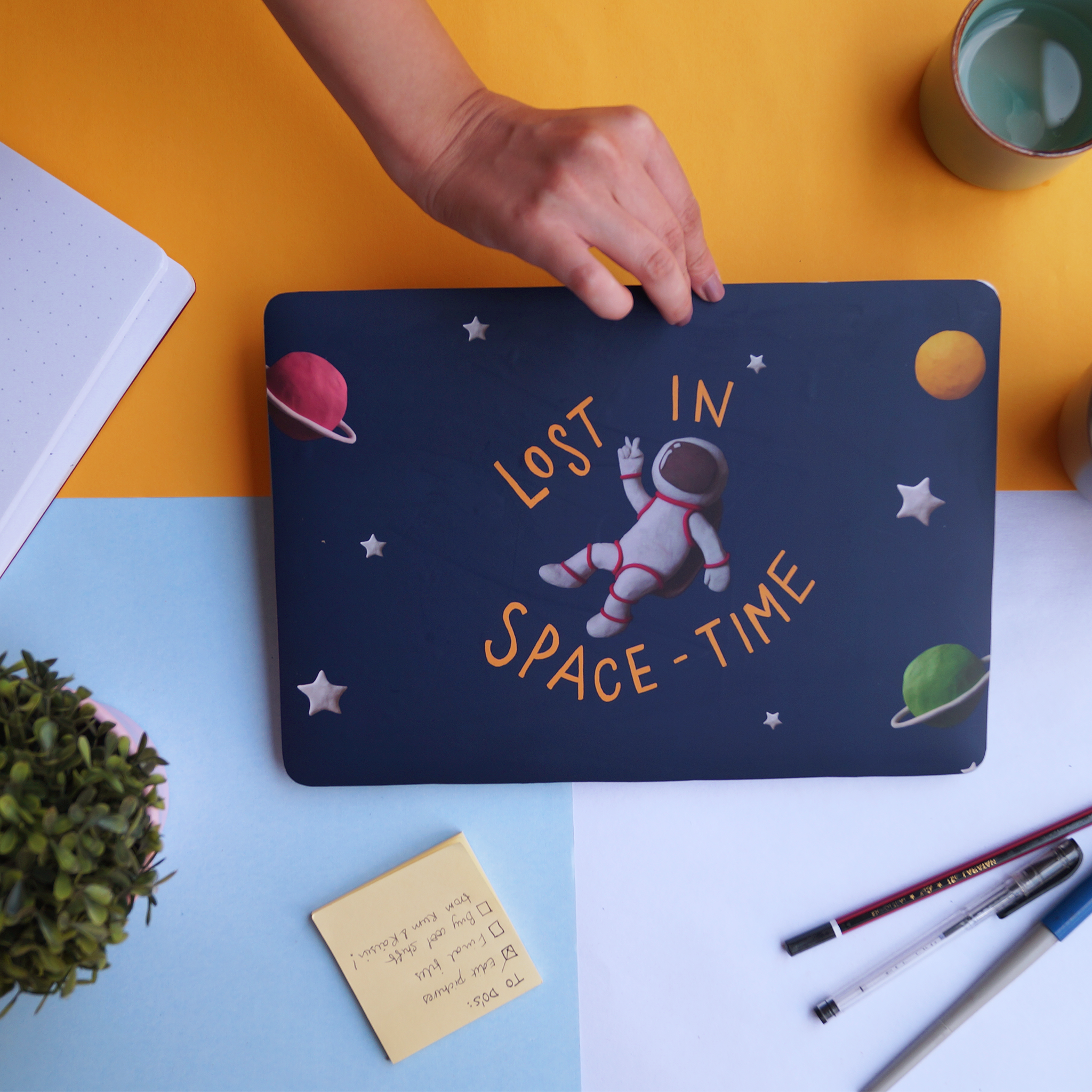 Blue laptop skin with a space theme with illustrations of astronaut, planet and stars
