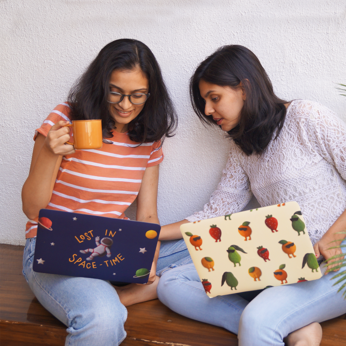 2 friends at work with their new laptop skins featuring clay illustrations