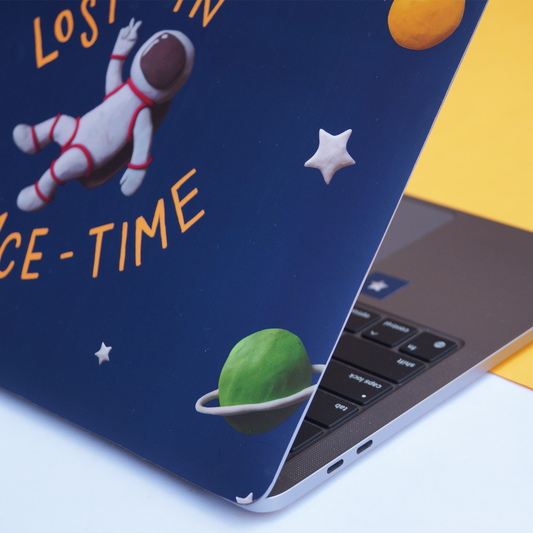 Close up of blue laptop skin showing an astronaut, stars and planets